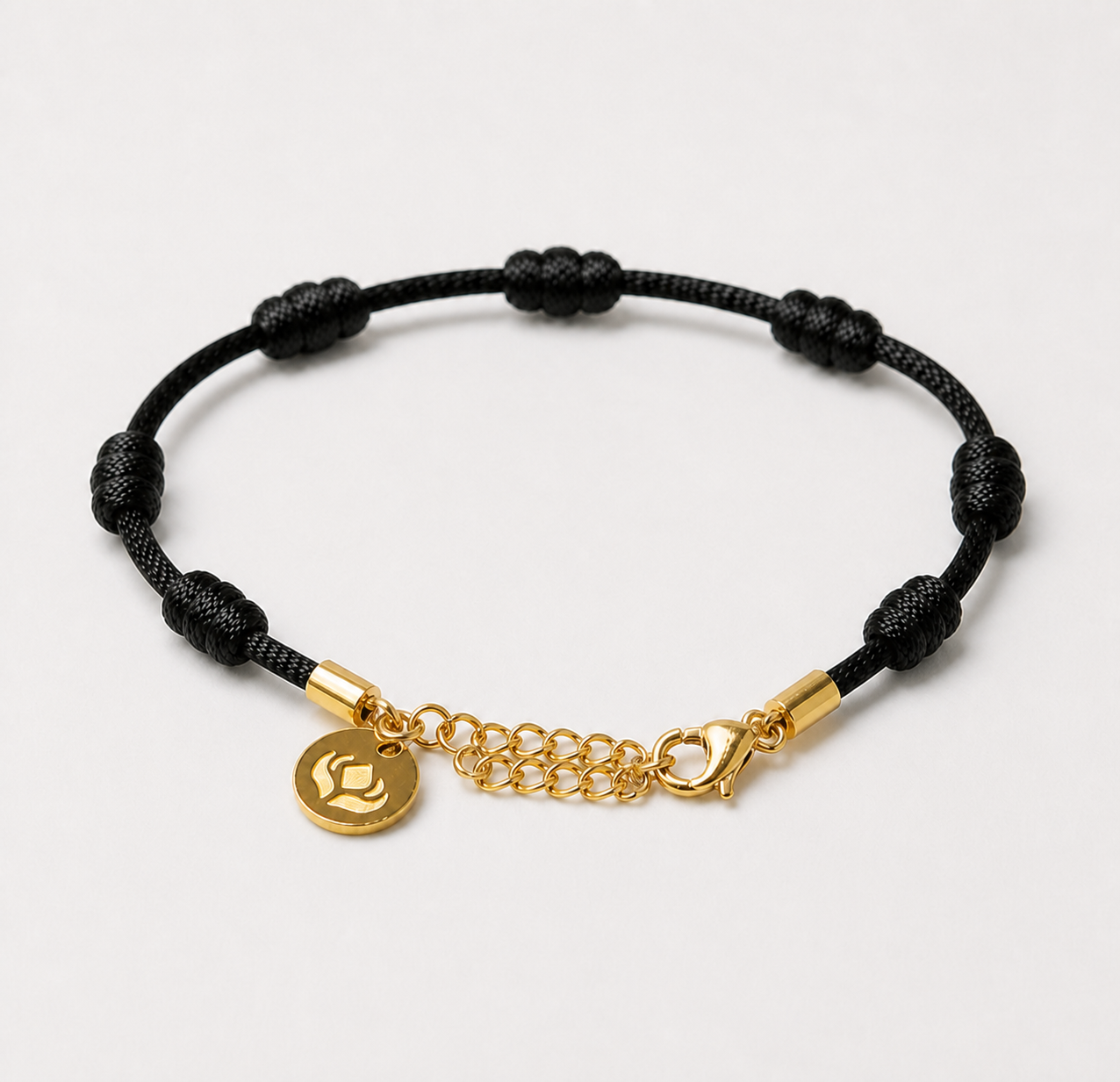 Pulseira Premium dos 7 Nós Preta com Dourado — detalhe do fecho e da medalhinha